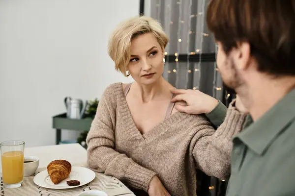 Una coppia gode di una colazione calda a casa, condividendo sorrisi e momenti teneri sul cibo. — Foto stock