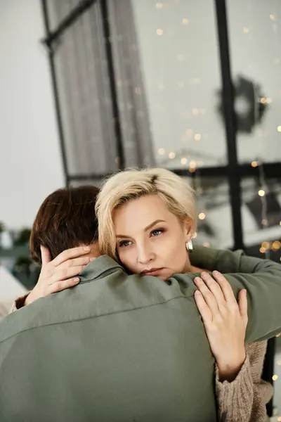 Un couple s'embrasse chaleureusement dans un espace de vie serein, rayonnant d'amour et de connexion. — Photo de stock