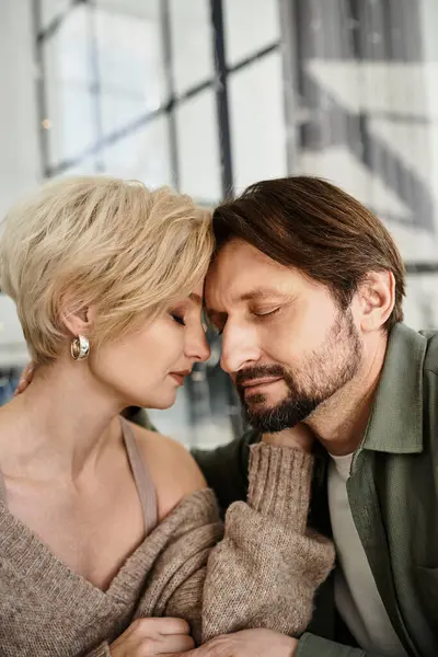 Two partners share an intimate and tender moment, closing their eyes and leaning into each other. — Stock Photo