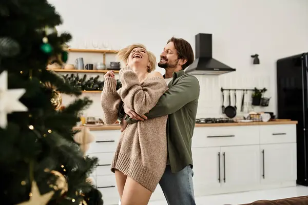 Ein Paar teilt Wärme und Lachen beim Umarmen in einer gemütlichen Urlaubsküche. — Stockfoto