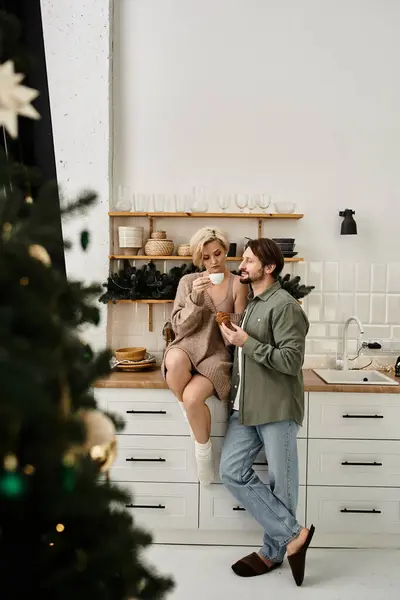 Um casal desfruta de uma bebida quente juntos em sua cozinha elegante, criando uma atmosfera amorosa. — Fotografia de Stock