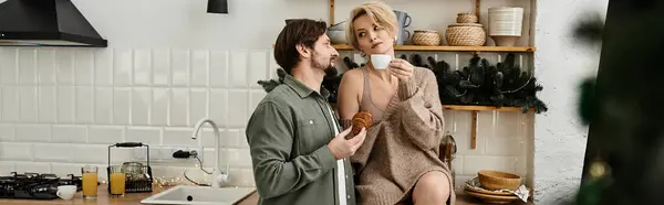 Una pareja disfruta de un tiempo íntimo juntos en su elegante cocina mientras saborea pasteles calientes. - foto de stock