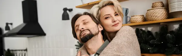 Ein Paar umarmt sich in seiner gemütlichen Küche und strahlt Liebe und Glück aus. — Stockfoto
