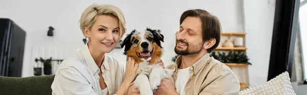 Um casal alegre valoriza seu tempo junto com um cachorro brincalhão em uma casa calorosa e acolhedora — Fotografia de Stock