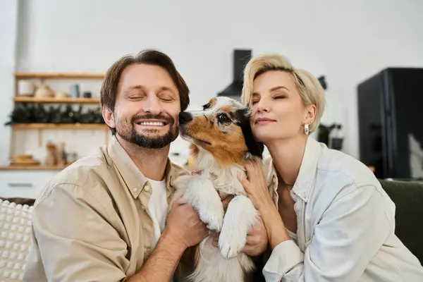 A couple embraces each other and their dog, radiating love in a cheerful home atmosphere. — Stock Photo