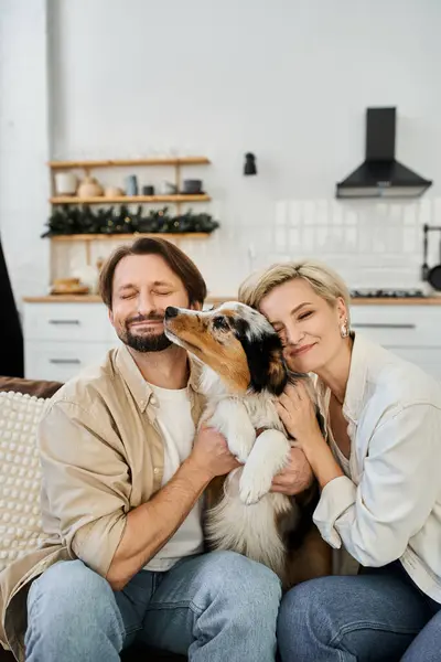 A loving couple embraces each other and their dog while enjoying a serene moment indoors. — Stock Photo