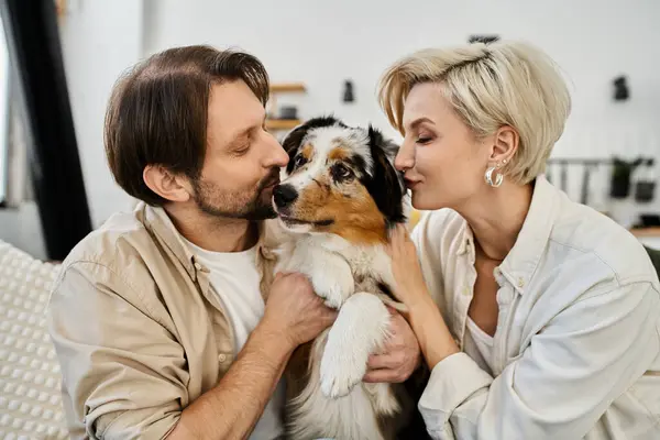 A couple joyfully embraces their dog while enjoying a peaceful moment together indoors. — Stock Photo