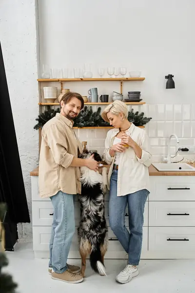 Una pareja comparte alegría en casa mientras interactúa con su perro en un ambiente cálido. — Stock Photo