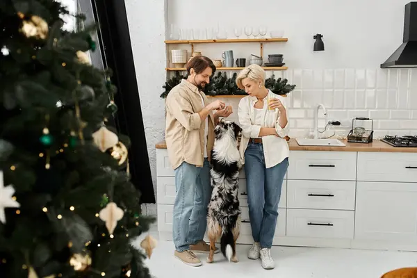 Ein Paar lächelt, als sie mit ihrem aufgeregten Hund in einer warmen und einladenden Ferienatmosphäre spielen. — Stockfoto