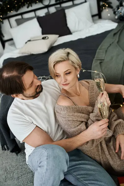 A couple enjoys a heartfelt moment together, celebrating with glasses in a cozy setting. — Stock Photo