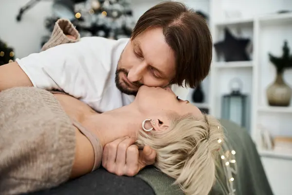 A couple embraces warmly on a couch surrounded by a soft, inviting atmosphere — Stock Photo