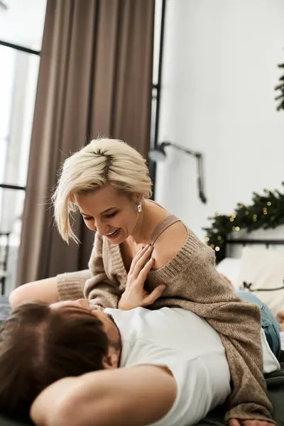 The couple shares a loving gaze while relaxing at home, surrounded by warmth and comfort. — Stock Photo