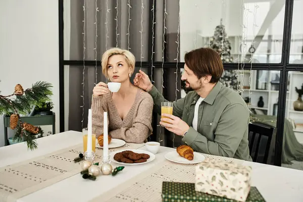 A couple enjoys breakfast together, sharing laughter and embracing love at home. — Stock Photo