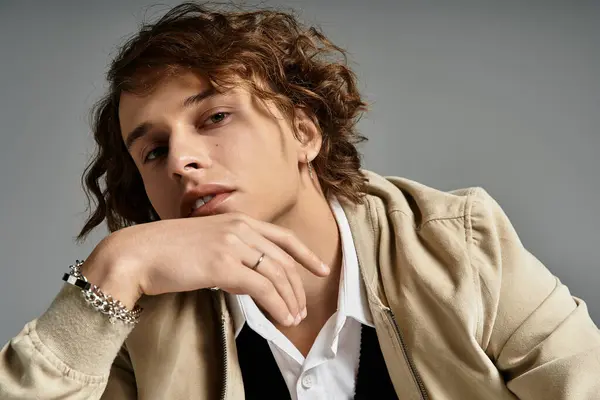 A handsome young man showcases a trendy autumnal look, posing thoughtfully in a stylish studio environment. — Stock Photo