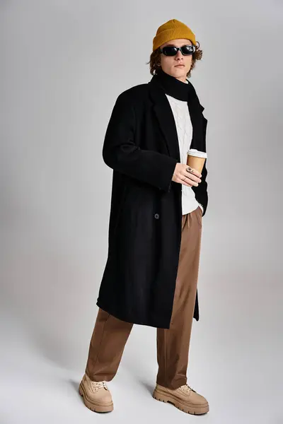 Un bel giovane uomo mette in mostra il suo vestito alla moda in uno studio elegante, irradiando fresco fiducia e fascino. — Foto stock