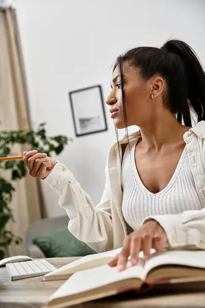 A beautiful young woman engages in her studies at home, concentrating intently on her notes. — Stock Photo