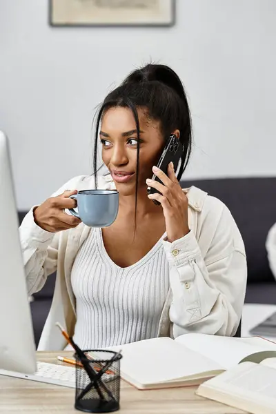 Una joven encantadora disfruta del aprendizaje remoto con café y una llamada telefónica. - foto de stock