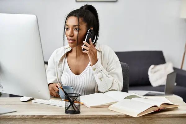 The woman is focused on her studies while taking important notes and talking on the phone. — Stock Photo