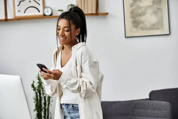 A smiling young woman studies from home, enjoying the comfort of her stylish living space. — Stock Photo