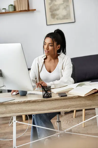 A young, beautiful woman engages in remote studying, focused on her work at home. — Stock Photo