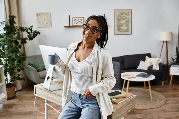 Esta mujer se relaja con una taza de café mientras estudia en su elegante espacio de trabajo en casa. — Stock Photo