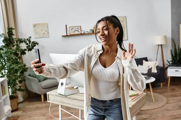 A cheerful young woman studies at home and enjoys connecting with others via video call. — Fotografia de Stock