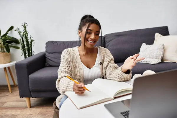 Una giovane donna si impegna nello studio a distanza dal suo confortevole ambiente domestico. — Foto stock