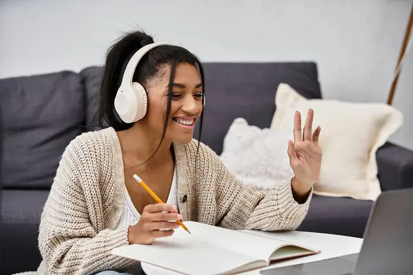 Uma jovem se envolve na aprendizagem remota de seu ambiente acolhedor em casa, sorrindo e focado. — Fotografia de Stock