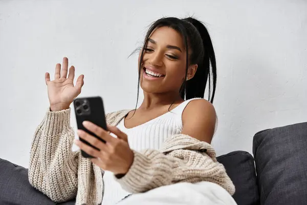 Una giovane donna allegra si impegna nell'apprendimento a distanza a casa, sorridendo mentre studia.. — Foto stock