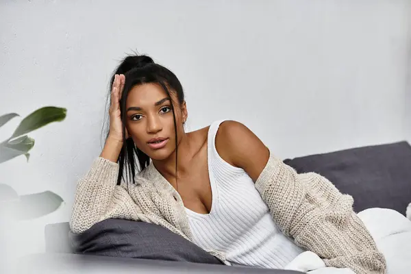A beautiful woman relaxes at home, deep in thought as she studies remotely, surrounded by comfort. — Stock Photo