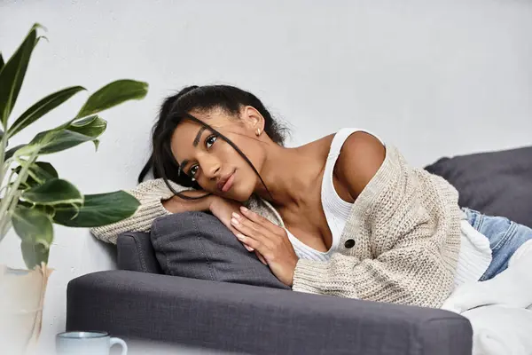 A young beautiful woman is thoughtfully studying at home in her cozy living space. — Stock Photo
