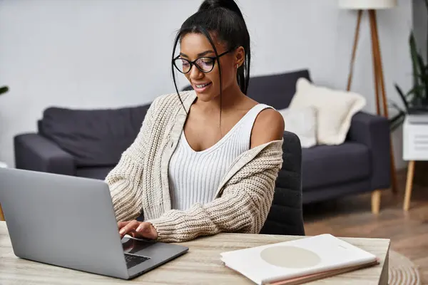 Una bella giovane donna si concentra sui suoi studi a distanza in un ambiente domestico elegante e invitante. — Foto stock