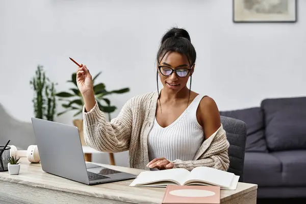 A beautiful young woman diligently studying at home, immersed in her learning environment. — Stock Photo