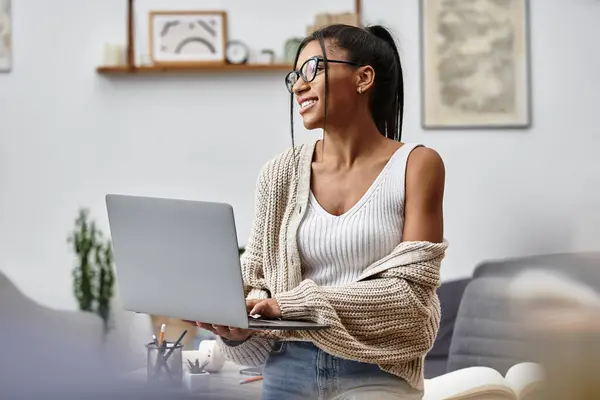 Eine schöne junge Frau lächelt, während sie fernab ihrer bequemen häuslichen Umgebung studiert. — Stockfoto