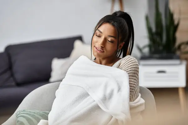 Una giovane donna si siede comodamente a casa, studiando a distanza e abbracciando il calore. — Foto stock