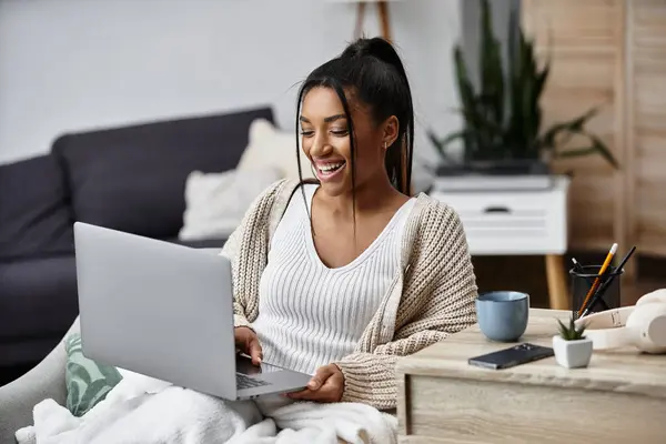 A cheerful young woman engages in remote studying at home while enjoying her cozy environment. — Stock Photo