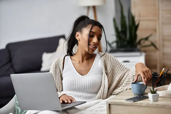 A beautiful woman is focused on her remote study session while relaxing at home. — Stock Photo