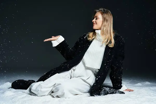 Una mujer joven baila juguetonamente con copos de nieve cayendo en un país de las maravillas de invierno. - foto de stock
