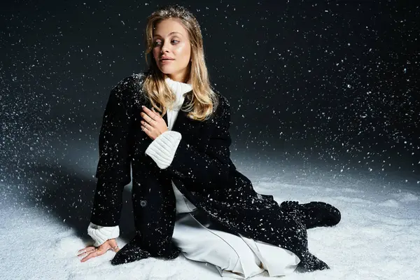 Una giovane donna dalle caratteristiche sorprendenti siede con grazia sulla neve, assaporando la bellezza invernale. — Foto stock