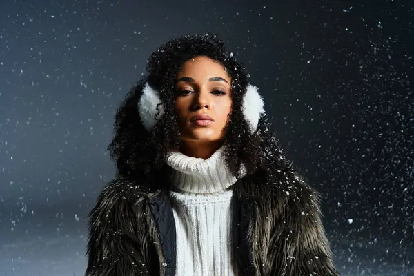 A beautiful brunette woman dons earmuffs and a faux fur jacket, exuding winter fashion elegance in the studio. — Stock Photo