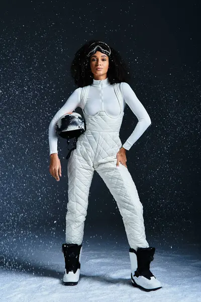 A stylish African American woman in a ski suit radiates confidence while posing in a modern studio. — Stock Photo