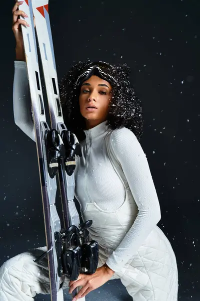 Eine atemberaubende brünette Frau präsentiert einen eleganten Skianzug, während sie Skier hält, und strahlt Charisma der Wintermode aus. — Stockfoto