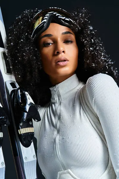 A beautiful brunette woman confidently models a chic ski suit, highlighting winter fashion in a studio. — Stock Photo
