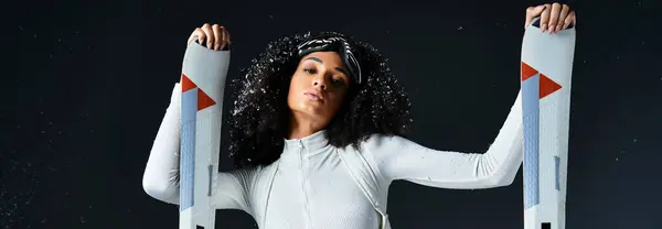 A beautiful African American woman confidently models winter sports fashion in a studio environment. — Stock Photo