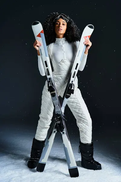 A beautiful brunette woman in a chic ski suit presents modern winter fashion with confidence and style. — Stock Photo