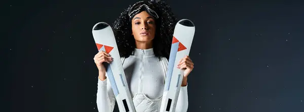A stylish brunette woman models a chic ski suit in a studio, ready to embrace the winter outdoors. — Stock Photo