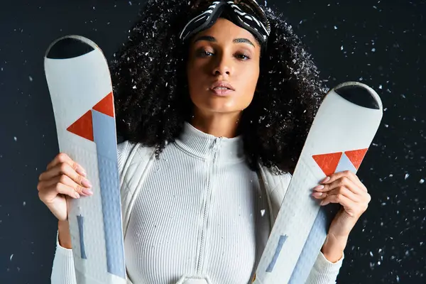 A beautiful brunette woman poses confidently in a ski suit, highlighting winter fashion trends in a studio. — Stock Photo