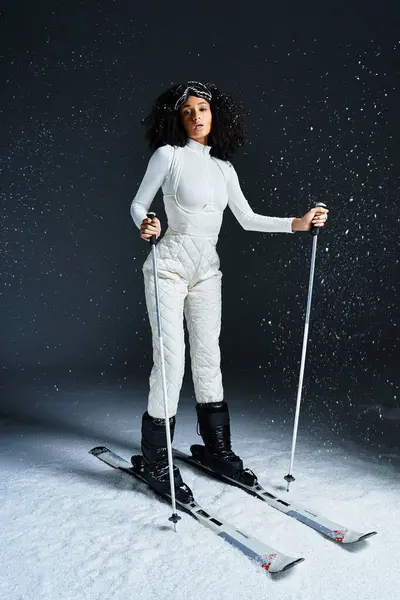 A beautiful brunette woman displays her trendy ski suit while posing gracefully with ski equipment. — Stock Photo