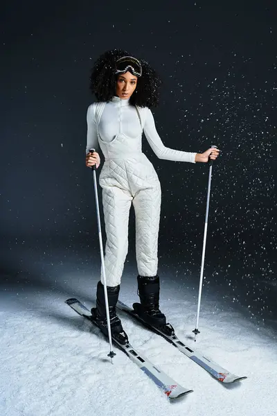 A stunning brunette African American woman models a sleek ski suit, exuding winter fashion in a studio setting. — Stock Photo