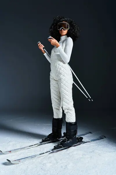 A beautiful brunette woman showcases trendy ski fashion while posing in a modern studio setting. — Stock Photo